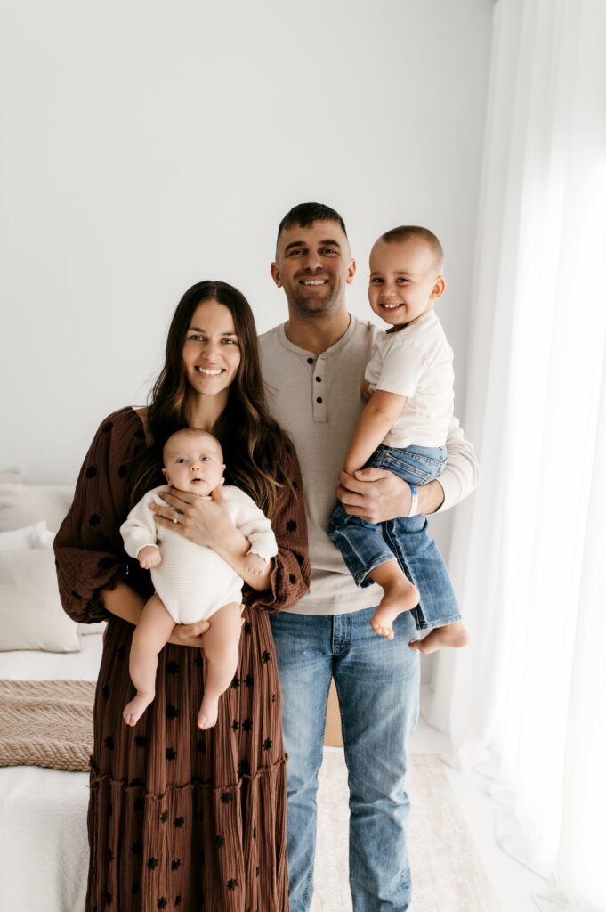 Coordinating family outfits in cream, tan, and brown in natural light studio session.