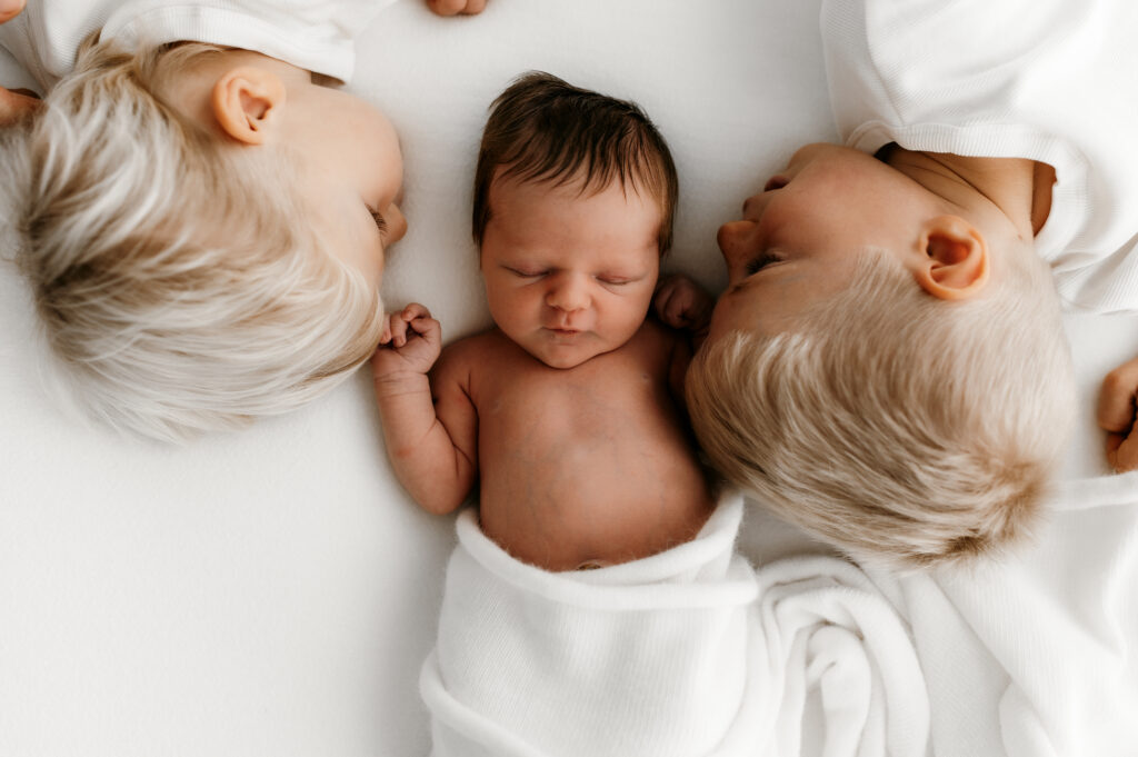 natural sibling interaction with newborn baby during lifestyle photography