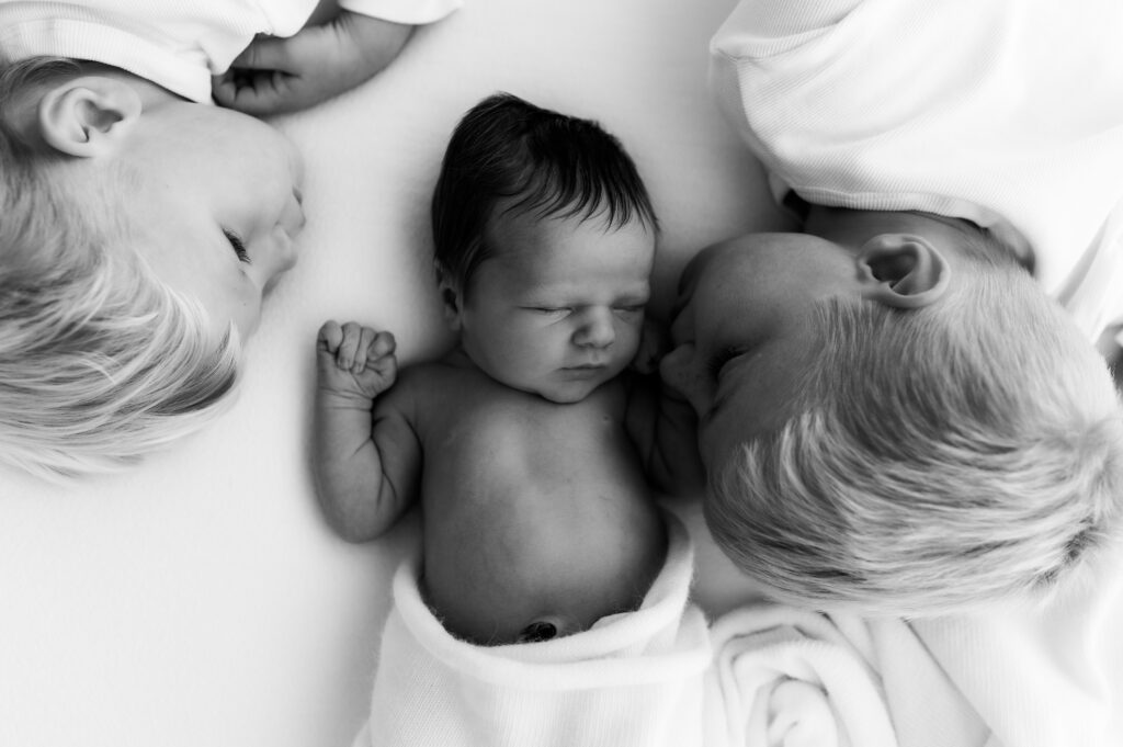 natural sibling interaction with newborn baby during lifestyle photography