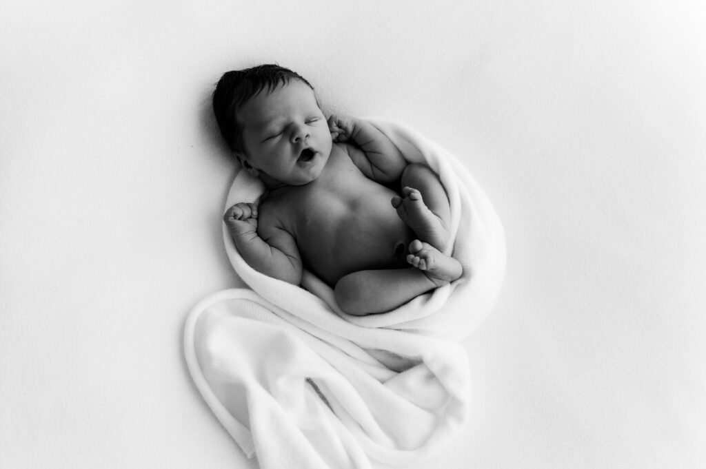 Yawning newborn baby photographed in a neutral Somerset WI photography studio