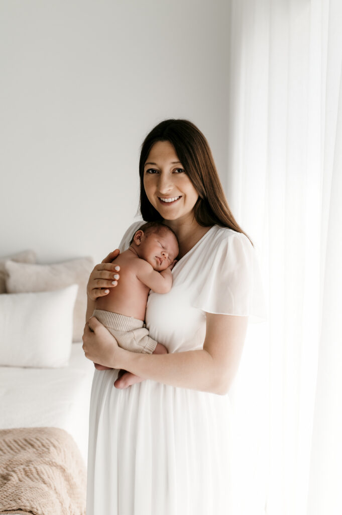 Mom hold newborn on her chest in natural light