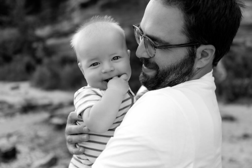 Dad smiling at baby in a black and white photo.